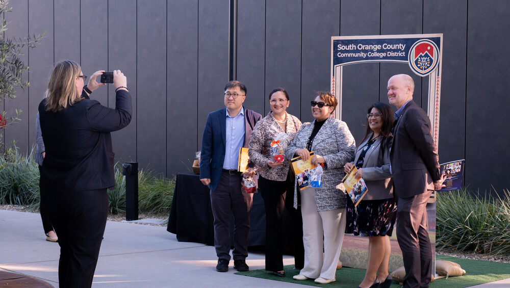employees take a photo in front of a photobooth