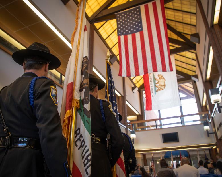 veterans standing and the american flag hanging