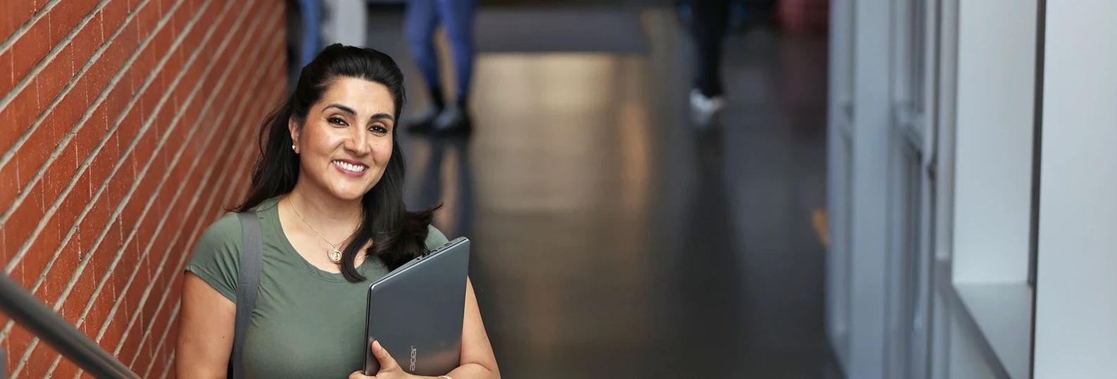 woman standing with notebook, looking at the camera