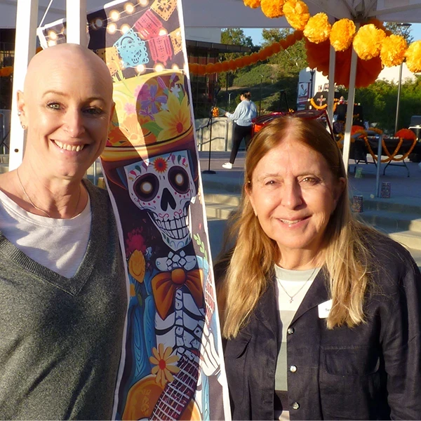 terri rydell and leaf fallbeck pose for phot at dia de los muertos event