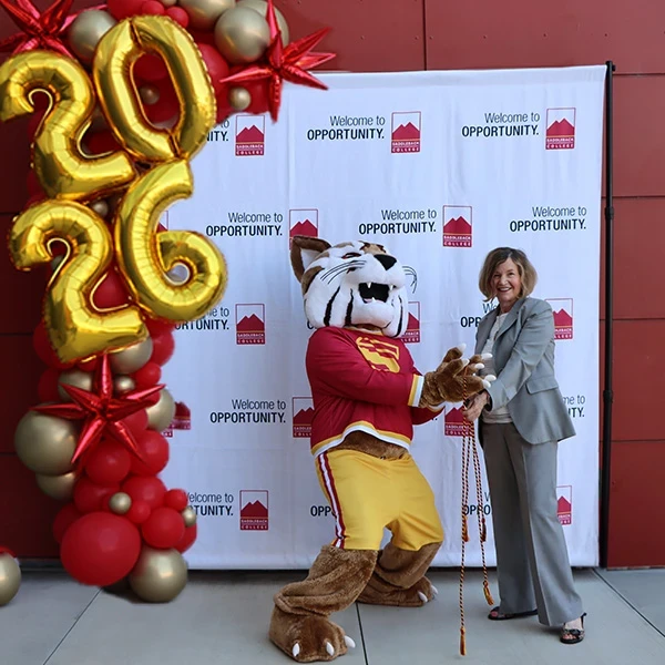 marcia Milchiker passes out cords with Saddleback Bobcat mascot Blaze