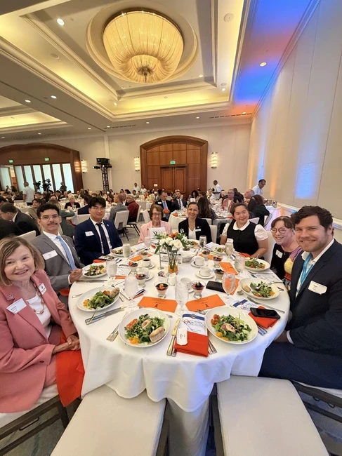 trustees at a dinner event in a ballroom