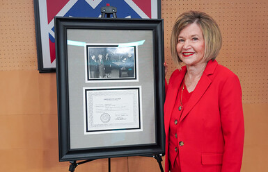Marcia Milchiker standing with award